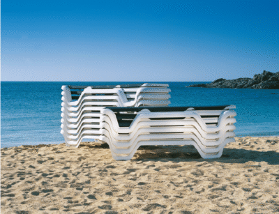 Lola sun loungers stacked on the sand facing the sea on a furnished beach