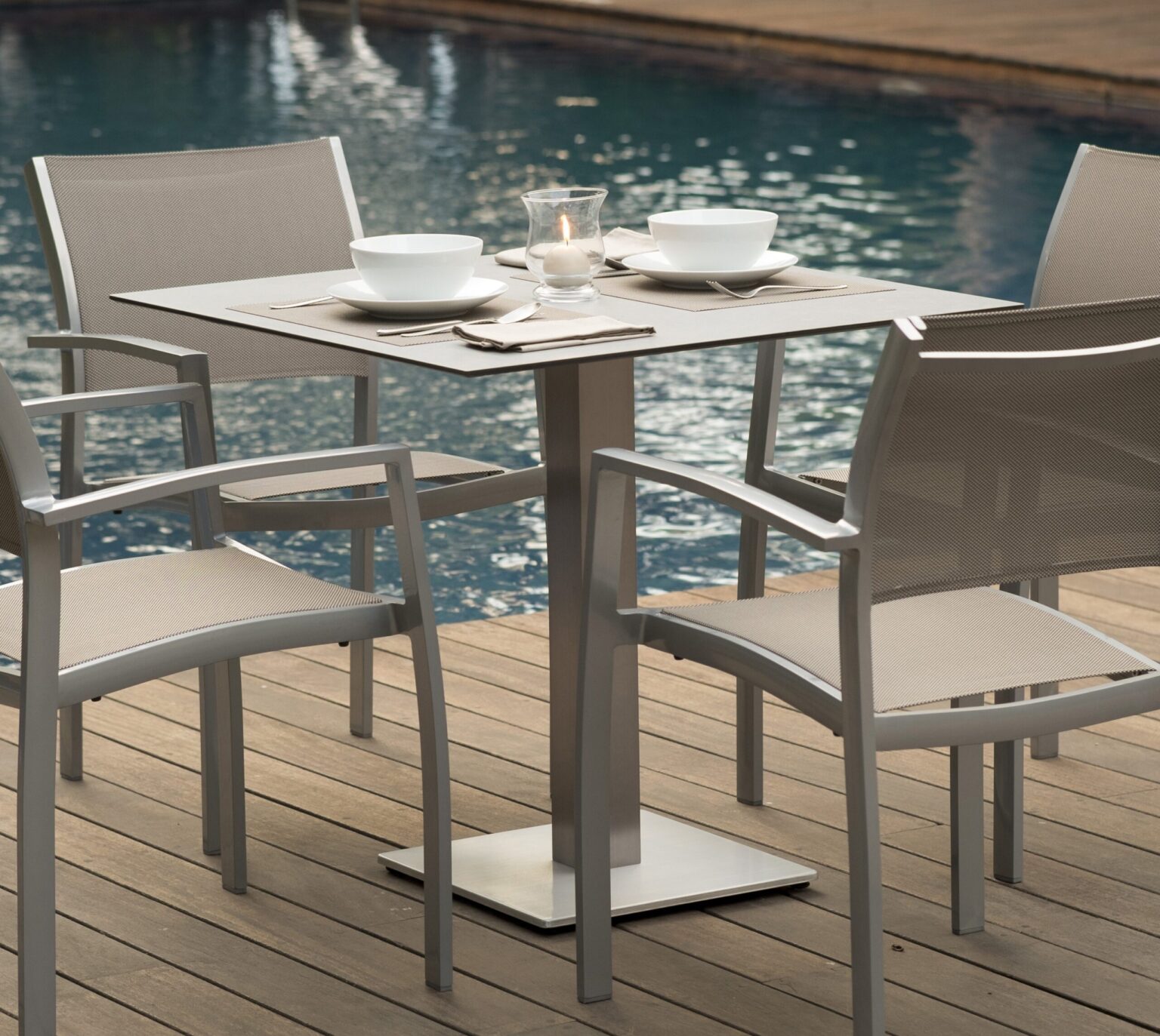 Two chairs are seen on a wooden floor and a modern, grey table.