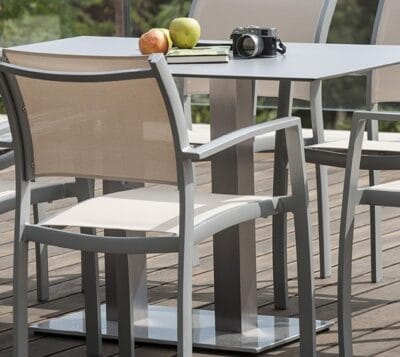 Se observan dos sillas sobre un suelo de madera y una mesa de diseño moderno y color gris