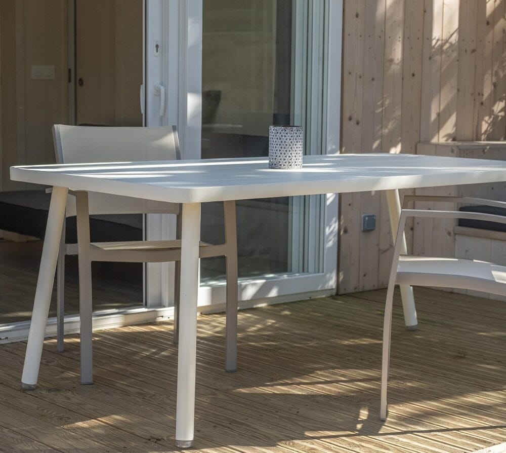 You can see two chairs next to the table on a parquet background