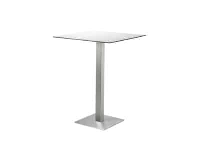 Imatge d´una taula moderna amb superfície quadrada de color gris clar i base central de metall cromat amb una pota inclinada. La taula té un disseny minimalista i contemporani, ideal per a bars o restaurants moderns