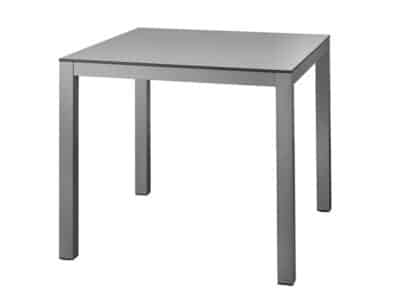 L'image montre une table carrée au design simple et moderne, avec une surface grise avec plateau en HPL et quatre pieds en aluminium de couleur grise. Le style est minimaliste et élégant