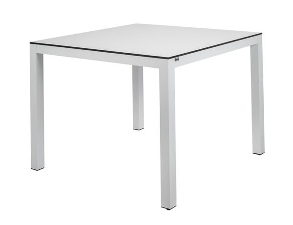 The image shows a square table with a simple and modern design, with a white surface with HPL top and four legs made of aluminum. The style is minimalist and elegant.
