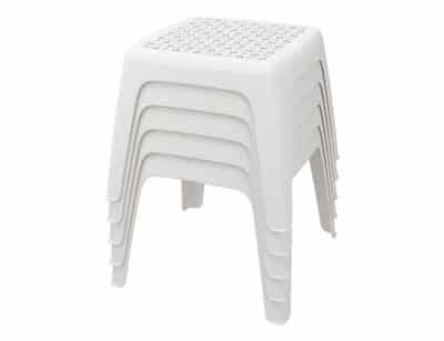 Cuatro mini mesas de resina de polipropileno blanco apiladas con diseño de superficie perforada y patas robustas, destacando su funcionalidad y ahorro de espacio