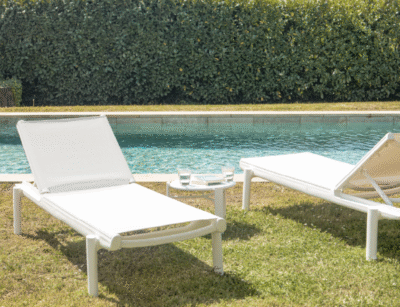 Tumbonas NOA blancas en césped, delante de una piscina