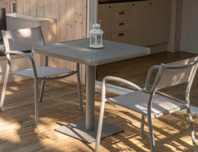 Two grey chairs are seen next to a grey table outside