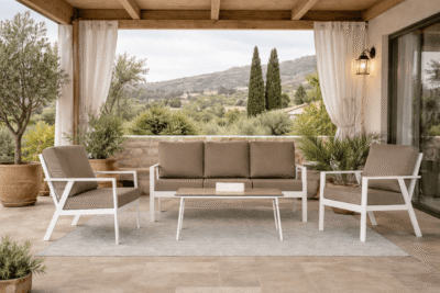 Conjunto exterior con sofá triple y dos sofás individuales de aluminio blanco, con mesa baja en terraza cubierta