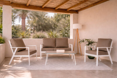 Conjunto exterior con sofá doble y dos sofás individuales de aluminio blanco, con mesa baja en terraza cubierta