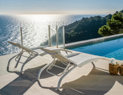 Tumbonas IRIS de aluminio junto a piscina con vistas al mar al atardecer