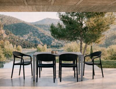 Mesa de exterior Brunei con sillas Duna negras en terraza contemporánea