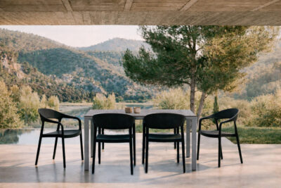 Mesa de exterior Brunei con sillas Duna negras en terraza contemporánea